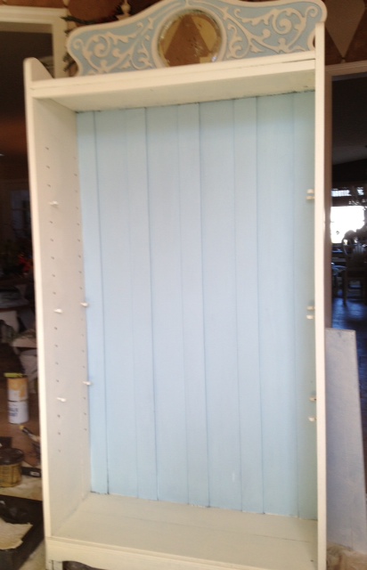 an antique bookcase revamped with off white and pale blue paint