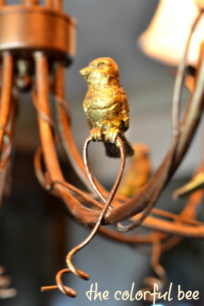 gold leafed and antiqued bird on a chandelier